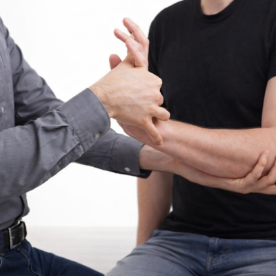Fisioterapeuta auxiliando paciente com mão